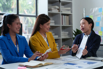 Asian business colleagues present and discuss investment project work and planning strategies. Budget calculation Income from documents reporting the company's business growth.
