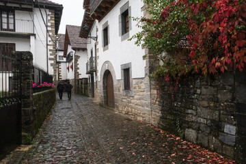 Dos turistas pasean por las calles típicas de Ochagavía, Navarra, España.