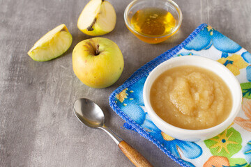 Baby healthy food. Homemade apple puree or sauce from organic apples in a bowl with fresh apples
