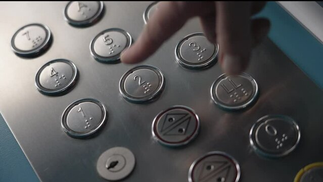 A woman pushes a floor button in an elevator. Closeup slow motion