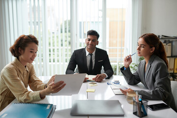 Multi-ethnic group of business people discussing report in meeting