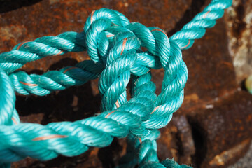 Close up of bright turquoise green/blue braided fishing rope on quayside in fishing village © brightimage