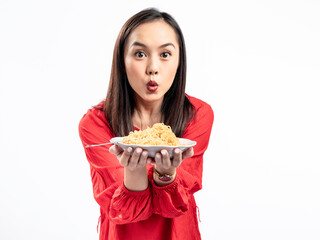 A portrait of a happy Asian woman wearing a red shirt, presenting noodles, and about to eat them. Isolated against a white background.