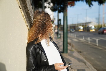 person walking on the street and waiting for a taxi while holding smartphone