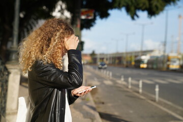 woman walking on the street and looking at her smartphone 