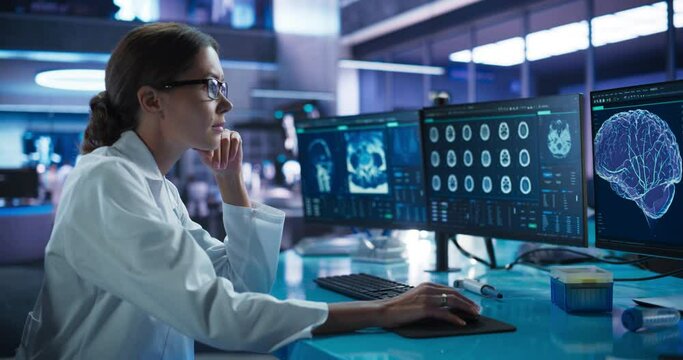 Hospital Research Laboratory: Female Medical Scientist Using Computer with Brain Scan MRI Images. Professional Neurologist Analysing CT Scan, Finding Treatment Solutions for Patient With Alzheimer's.