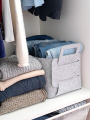 Felt baskets for storing things. Two felt boxes in the closet with neatly folded jeans and...