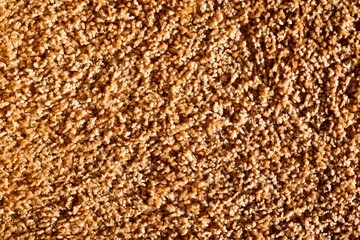Brown carpet texture. Closeup fiber background. Soft plush fabric pattern. Furry rug background. Grainy noise design. Textile background.