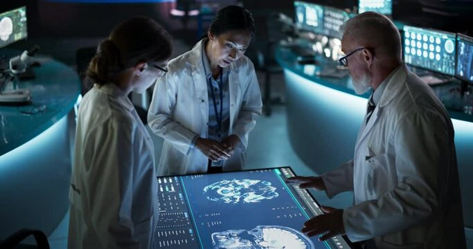 Modern Hospital Medical Research Center: Diverse Colleagues Gathered Around Interactive Touch Screen Table With MRI Scans Of Brain On Display. Doctors Discussing Rehabilitation Solutions After Stroke.