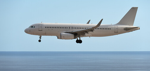 Obraz premium The plane lands over the ocean.Airplane, passengers flying in the sky, preparing to land at the airport
