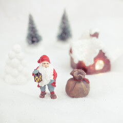 christmas decoration santa claus standing outside cottage in snow