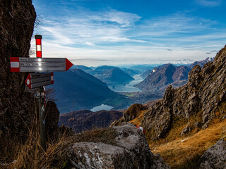 Path signs on a trail in the alps of Lake Como ( the writes on the arrows are the name of the...