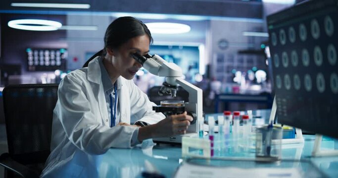 Medical Research And Development Center: Female Asian Scientist Using Microscope To Analyze Petri Dish Sample. Specialist Developing Innovative Medicine For Treating Mental Disorders Or Pain Relief.