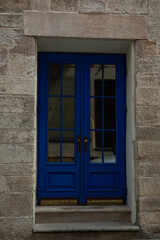 Fototapeta na wymiar Brick building facade, steps and blue doors outdoors