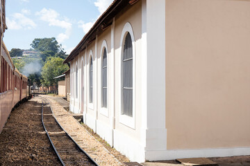Old train station in São João del Rei, via ferrea with train passing by