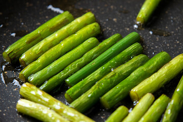 にんにくの芽をフライパンで炒める調理シーン。
