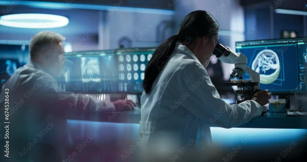 Fototapete female asian scientist using microscope to analyze petri dish sample in biotechnology research cente