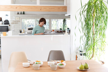 食事の準備する日本人のミドル女性、観葉植物
