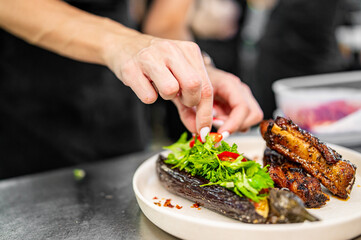 chef Cooking of grilled pork ribs with baked eggplant at the restaurant kitchen