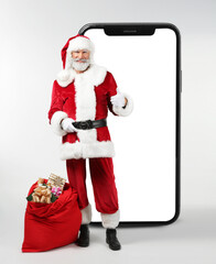 Portrait of Santa Claus with bag full of gifts on white background