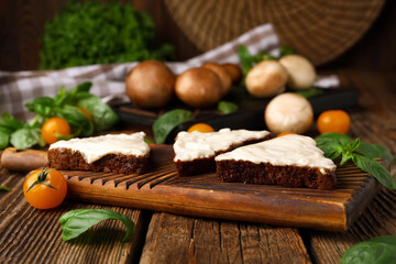 Board of tasty sandwiches with cream cheese on wooden background