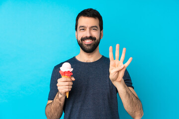 Young man with a cornet ice cream over isolated blue background happy and counting four with fingers