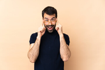 Fototapeta premium Caucasian handsome man over isolated background with glasses and surprised