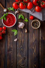 Tomato sauce passata in bowl with fresh tomatoes and basil