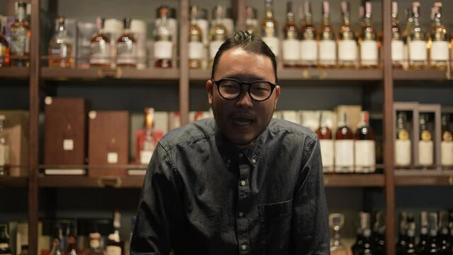 Night club concept of 4k Resolution. Asian bartender is confidently guiding customers in the shop. A group of specialized clubs that sell alcoholic beverages.
