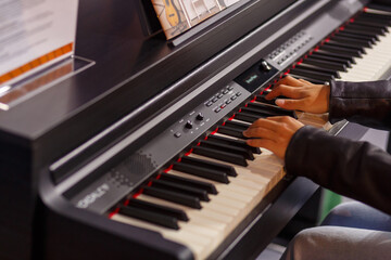 Fototapeta na wymiar A musician's hands test a piano at an exhibition of musical instruments