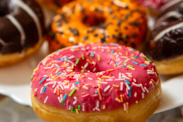 Donuts with multi-colored glaze on a plate for the Hanukkah holiday close-up