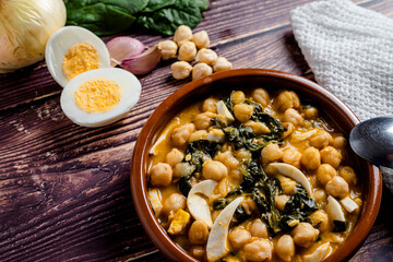 Delicious and traditional dish of chickpea stew with spinach and egg - obrazy, fototapety, plakaty