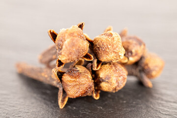 Dry aromatic cloves, macro, on slate stone.
