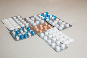 A set of medicines, pills in transparent plates on a gray background. Top view