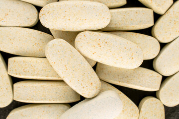 Several medical pills  on slate stone, macro, top view.
