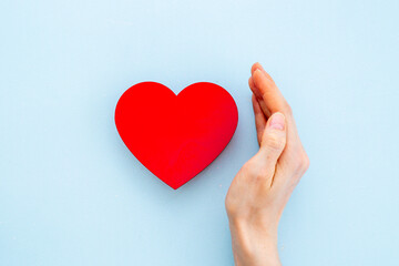 Red heart in female hands. Valentines day or health care concept