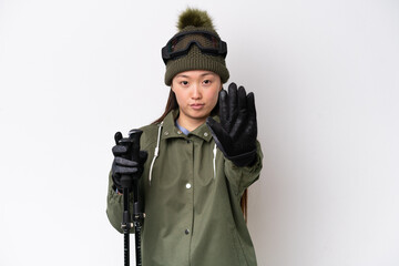 Young Chinese woman wearing winter jacket isolated on white background making stop gesture