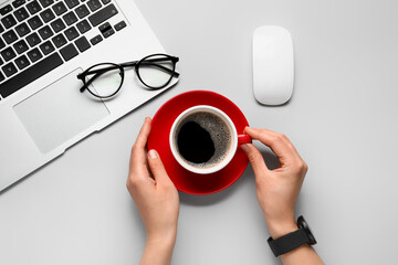 Female hands with cup of hot coffee and eyeglasses on white background