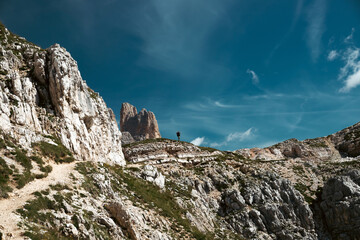 Stunning view of a tourist enjoying the view of the Tre Cime Di Lavaredo, Dolomites, Italy.
