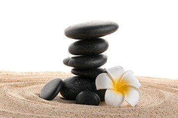 Stack of zen stones with white flower on sand. Harmony with nature concept