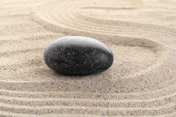Schilderijen op glas Black stone on sand background. Zen concept. © Pixel-Shot