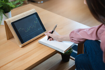 stock trade at home.  Close up hand of person learning and analyzing the chart of stock market via application