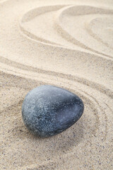 Fototapeta na wymiar Zen meditation stone in sand with wave pattern background, zen concept
