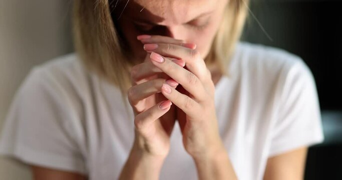 A woman prays with lowering her face, a close-up, slowmotion. Concept religious freedom, search for assistance