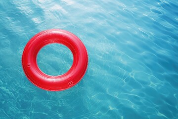Close-up view of a red swimming ring in clear sea water with beautiful light pattern on beach. Summer tropical vacation concept.