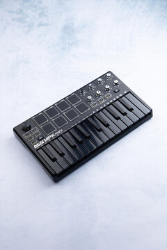 AKAI mpk mini mk2 black on a blue and white background. Side view