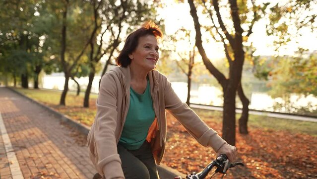 Old woman riding bicycle in public park