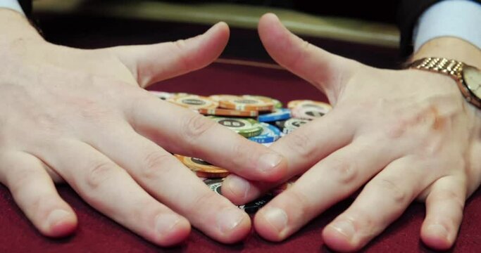 Man playing poker in casino. Close-up of hands with chips