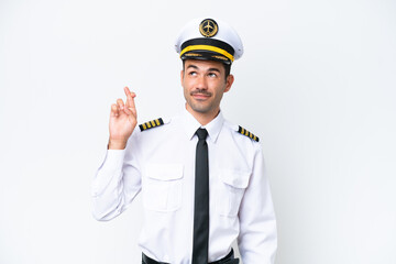 Airplane pilot over isolated white background with fingers crossing and wishing the best