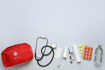 First aid kit and pills on grey background
